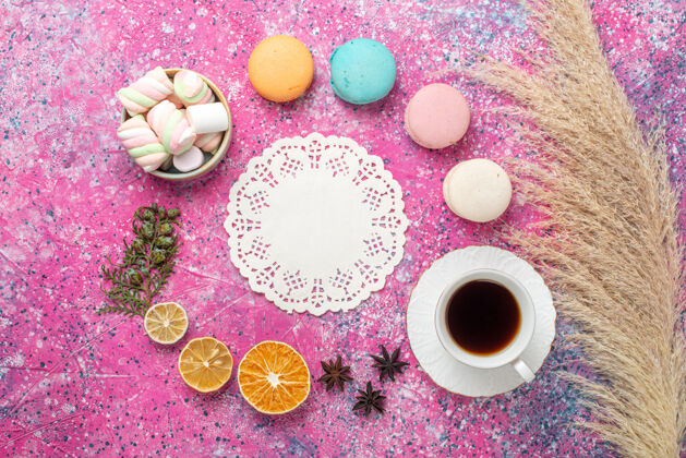 法国顶视图的法国麦卡龙棉花糖和茶杯上粉红色的表面生的糖派