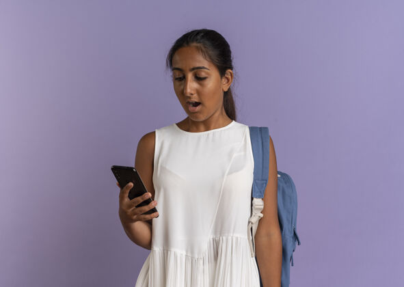 包惊讶的小女生背着书包拿着手机看着紫色的电话惊喜年轻