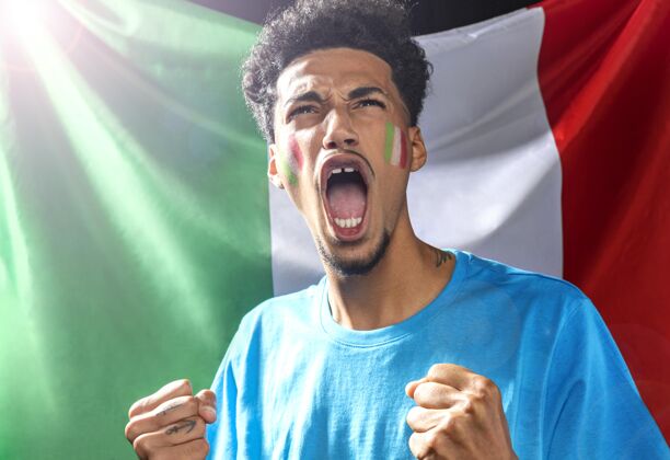 国旗手持意大利国旗的啦啦队队员的正视图比赛人足球