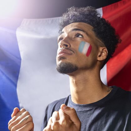 广场侧视图的人与法国国旗抬头 并举行拳头在一起足球比赛国旗足球比赛
