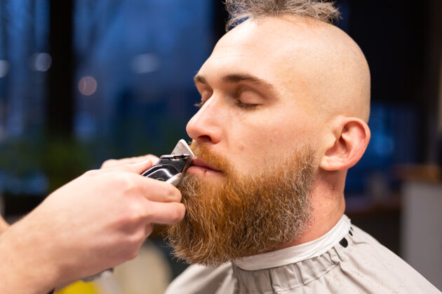 清洁在理发店剪胡子的欧洲野蛮人客户家伙时髦