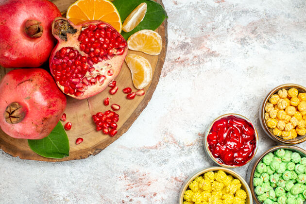 石榴顶视图甜糖果与新鲜水果的白色背景糖糖果水果甜观点草莓盘子