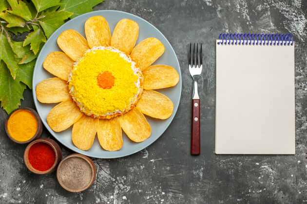 柑橘在黑暗的背景下 从左侧和从右侧的叉子和记事本与香草和叶子沙拉俯视图水果早餐背景