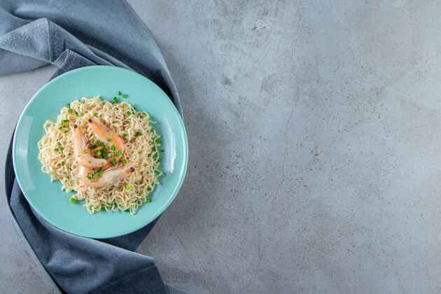 拉面面条和虾放在一块布上 放在大理石背景上午餐一餐美味