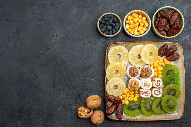 食物顶视图切片干果菠萝环和猕猴桃灰色背景干果葡萄干甜维生素酸健康晚餐午餐生的