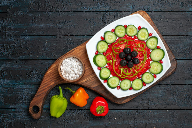 美食俯视图在深色的乡村桌子上的盘子里放着橄榄黄瓜片减肥沙拉蔬菜维生素健康乡村午餐蔬菜