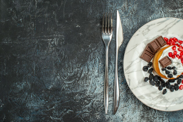 厨房顶视图美味的奶油蛋糕葡萄干和一杯茶的浅暗背景钢勺子糖