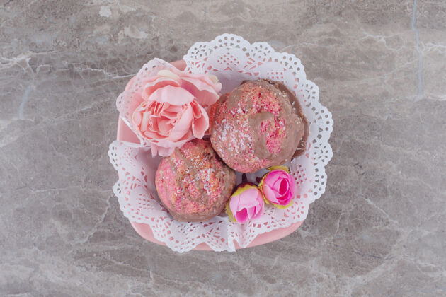 烘焙小蛋糕和花冠放在一个铺着桌布的碗里 放在大理石上碗美味美味