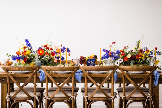 木一张桌子的水平镜头 木制椅子上装饰着五颜六色的鲜花和蜡烛空的经典的墙