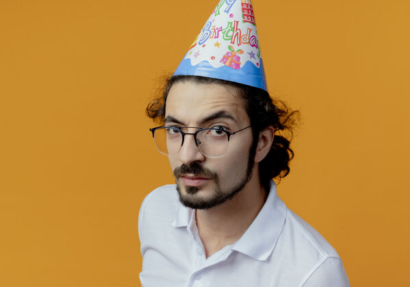 穿着戴着眼镜和生日帽的帅哥严格隔离在橙色上男人生日严格