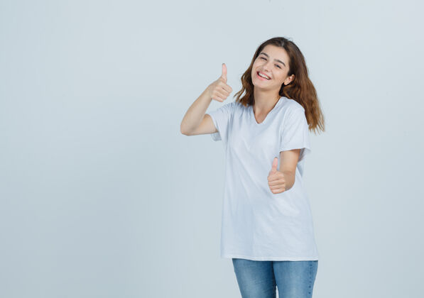 肖像年轻的女士在t恤衫 牛仔裤中竖起大拇指 看起来很高兴 正面视图护理成人健康