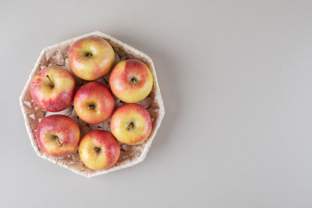 美味放在大理石上的白篮子里的苹果饮食天然风味