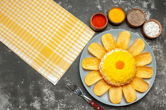 健康沙拉的顶视图在左侧 药草叉和黄色餐巾在深灰色背景上柑橘叉子新鲜