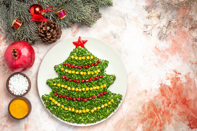 树顶视图美味的绿色沙拉在新年树形状与调味品在轻背景健康圣诞节光