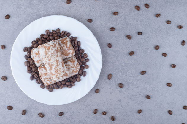 曲奇俄罗斯普莱尼克饼干和咖啡豆放在大理石盘子上可口糕点甜点