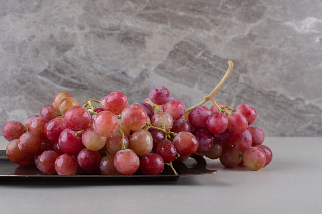 天然红葡萄放在大理石上的小托盘上配料有机多汁