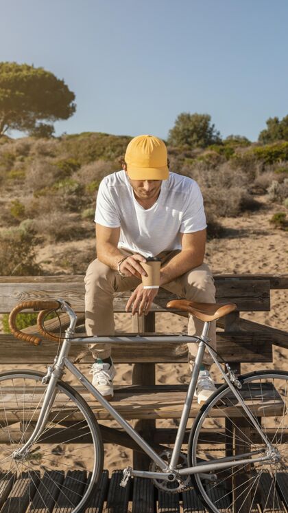 健康坐在长凳上骑自行车的人自然放松年轻
