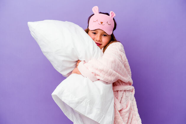放松小女孩抱着一个枕头快乐地孤立在紫色上可爱睡觉梦