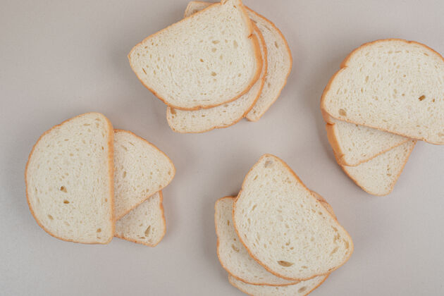 营养把新鲜的白面包片放在白色的表面上糕点皮美味