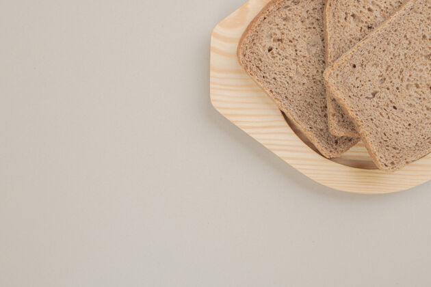 糕点把新鲜的棕色面包片放在木盘上面包美味烘焙