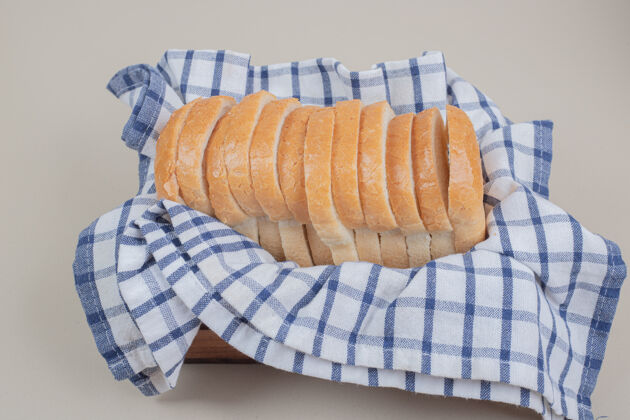美食把新鲜的白面包片放在桌布上面包房膳食美味