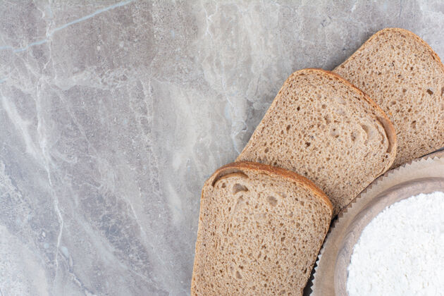 切片在大理石表面用面粉做的棕色面包片膳食糕点食物