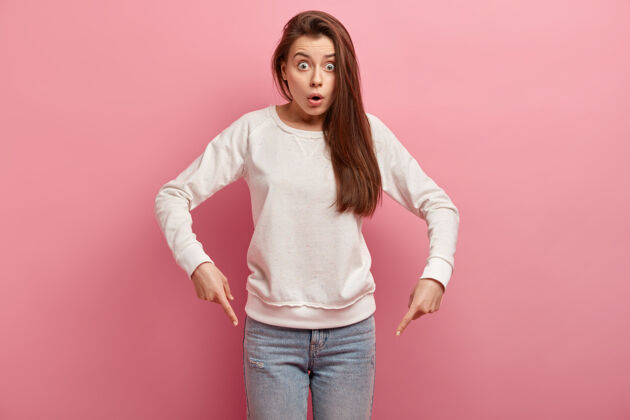 成人穿着牛仔裤和毛衣的年轻黑发女人牛仔裤肖像惊喜