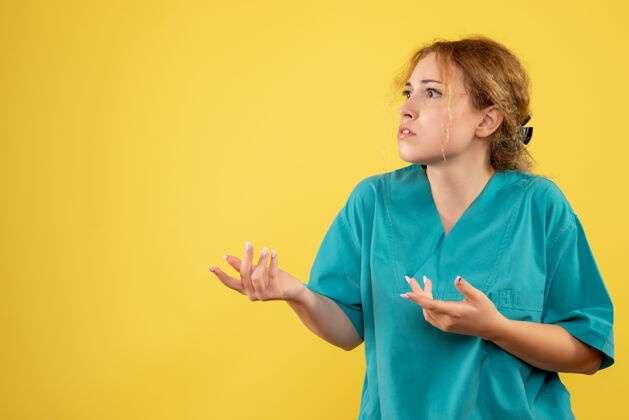 女人正面图黄色桌子上穿着医疗衬衫的女医生健康医疗护士covid-19颜色人女性颜色