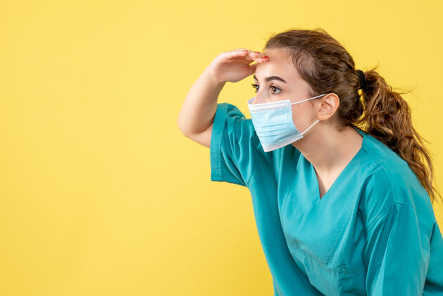 肖像正面图女医生穿着医用衬衫 戴着消毒口罩遥望远方 健康病毒颜色一致颜色面具黄色
