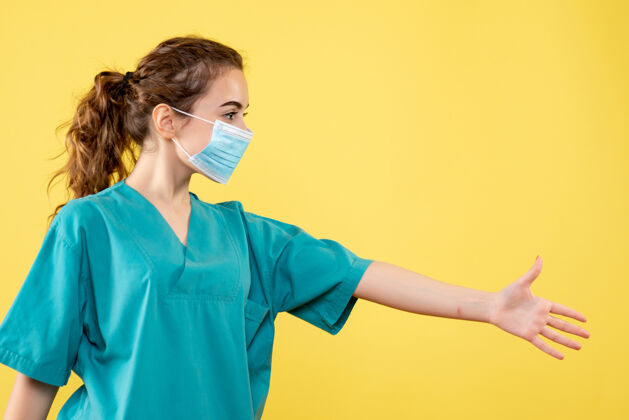 女人正面图女医生穿着医用衬衫和无菌口罩握手 彩色健康病毒制服covid-成人黄色消毒