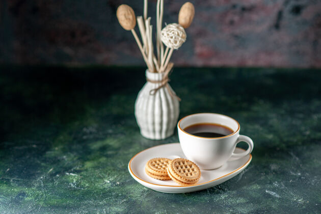 风景前视一杯茶 配上小甜饼 在白色盘子里 在深色的表面上摆上彩色的早餐 早餐 照片 面包 玻璃杯 饮料茶杯咖啡早晨