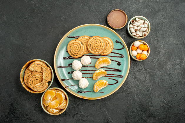 膳食顶视图饼干和糖果与橘子在灰色的桌子甜甜饼干饼干早餐食物可食用坚果