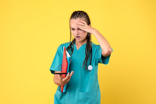 人身穿医疗服的女医生正拿着电话和黄色墙上的笔记健康笔记电话