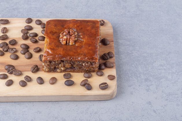 甜点在大理石桌上的木板上放上烤面包和咖啡豆佳肴美味咖啡