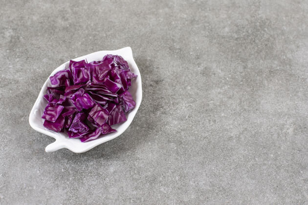蔬菜把红卷心菜切成片放在碗里 放在大理石桌上成熟的健康卷心菜