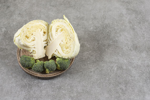 健康把卷心菜和花椰菜切成薄片放在木板上 放在大理石桌上小吃滋补的西兰花
