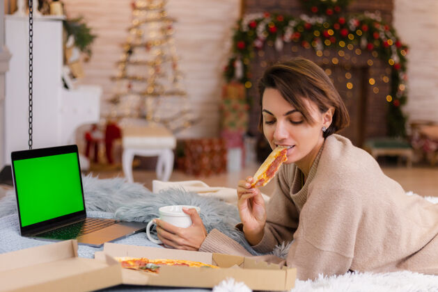 吃饭女东快餐比萨饼从送在床上的卧室在家里在圣诞节新年的时候女士饿在线
