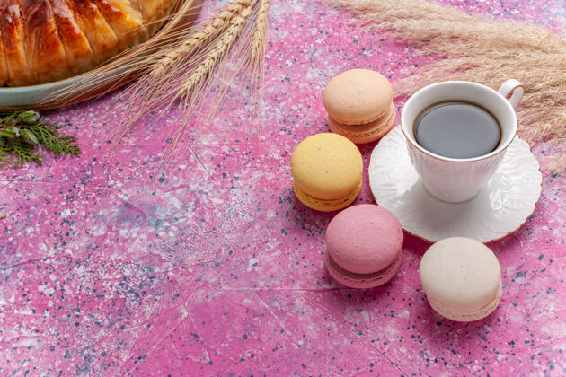 茶俯瞰美味的草莓派 在粉红色的蛋糕上放上一杯茶和麦卡龙杏仁饼咖啡糖果