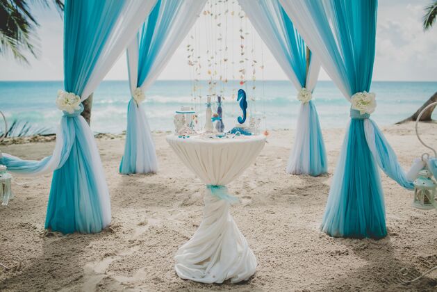 花蓝白相间的婚礼走道在一片棕榈树环绕的海滩上 背景是大海庆祝海洋花