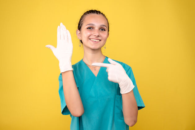 医院黄墙上戴着特制手套的女医生正面图特殊戴人