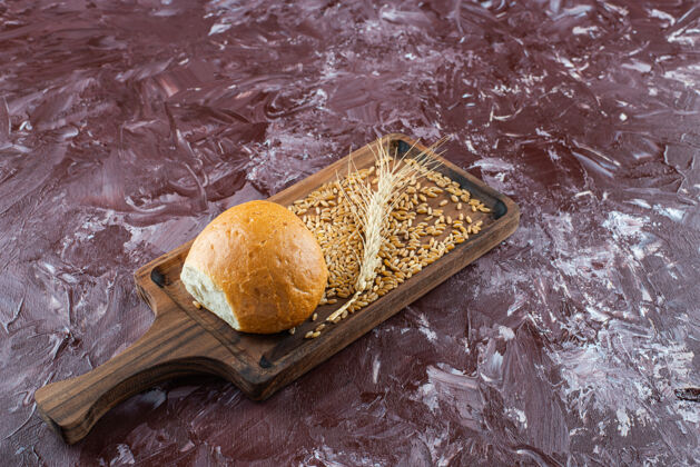 美味一块用新鲜的白面包做成的木板 背景光是小麦穗食物耳朵小麦