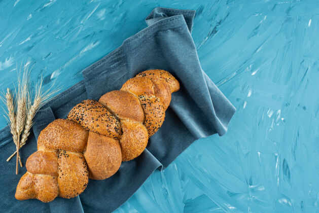 新鲜刚出炉的编织面包 放在深色桌布上形状面包食物
