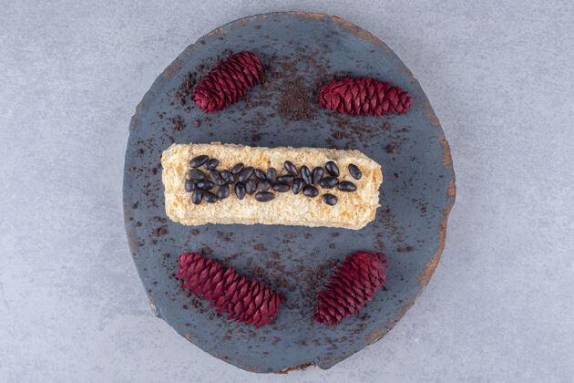 蛋糕巧克力蛋糕和红松果放在大理石桌上的木板上糕点松树烘焙食品