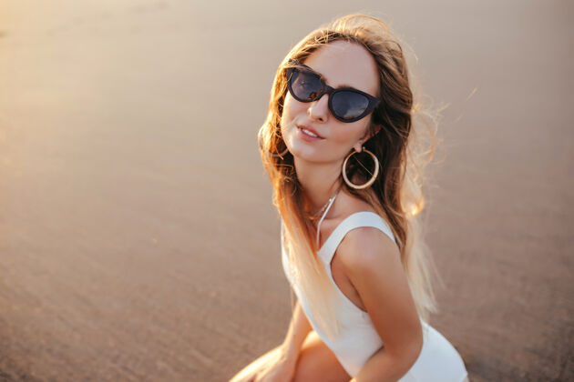 无忧无虑迷人的白种女人戴着时髦的耳环在沙滩上摆姿势度假放松享受热带