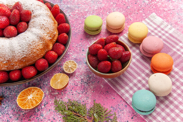 美味正面图糖粉派草莓蛋糕 粉红色的麦卡龙蛋糕碗水果