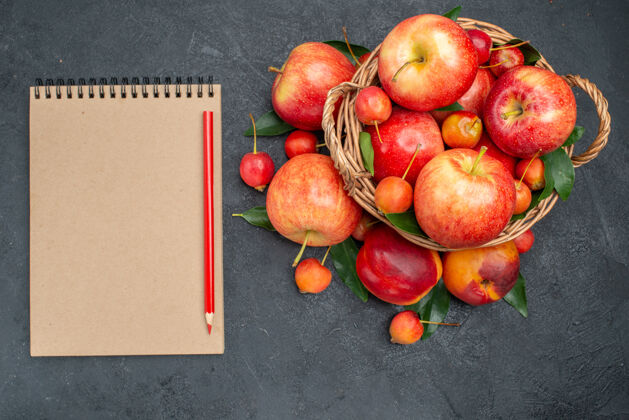 木头顶视图水果和浆果与树叶在木制篮子奶油笔记本铅笔健康奶油笔记本