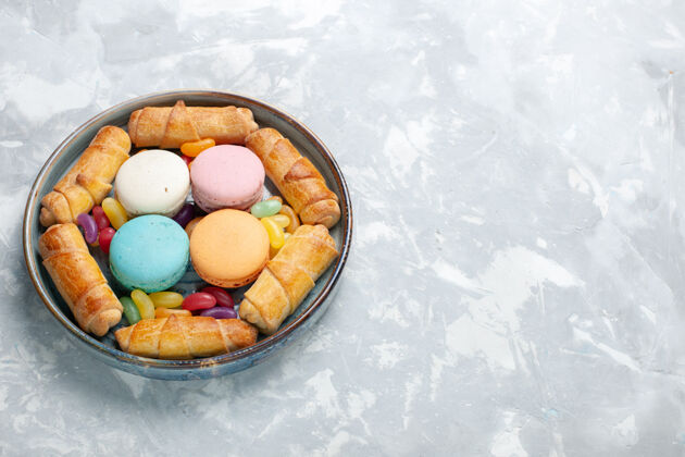 美味白色托盘内的麦卡龙和百吉饼俯视图杏仁饼食物糖果