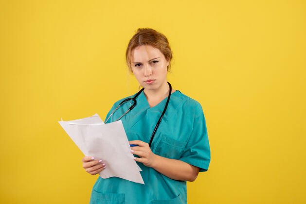 女医生黄墙上穿着医疗服的女医生手持分析图分析人医院