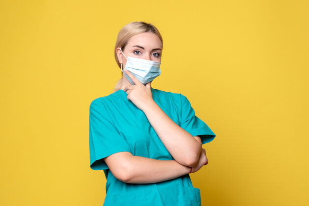 人前视图穿着医用衬衫和面罩的女医生 covid-19护士 健康大流行医生女性黄色肖像