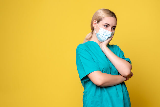 成人黄墙上年轻女医生穿着医用衬衫 戴着口罩的正面图人护士流行